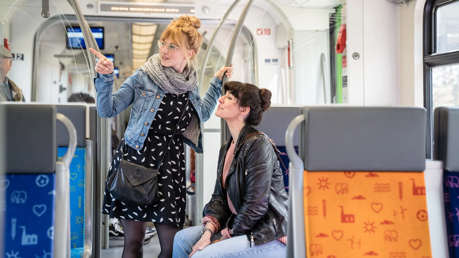 Zwei Frauen sitzen und stehen in der S-Bahn 